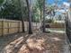 View of the backyard with a wooden fence, trees, and an area for recreational activities and storage at 203 N Sweetwater Blvd, Longwood, FL 32779