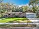 Charming single-story home featuring a manicured lawn, brick accents, and a two-car garage at 203 N Sweetwater Blvd, Longwood, FL 32779