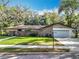 Charming single-story home with a manicured lawn, brick accents, and attached two-car garage at 203 N Sweetwater Blvd, Longwood, FL 32779