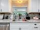 Granite countertops with white cabinets surround the sink and window overlooking a lush exterior at 203 N Sweetwater Blvd, Longwood, FL 32779