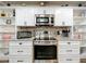 Modern kitchen featuring stainless steel appliances, granite countertops, and white cabinetry at 203 N Sweetwater Blvd, Longwood, FL 32779