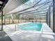 An enclosed pool, with the pool surrounded by white concrete, features a lounge area and a grilling area at 203 N Sweetwater Blvd, Longwood, FL 32779