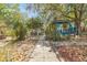 Backyard features a stone path and ample foliage leading to a patio seating area for relaxation and enjoyment at 209 S Hydrangea Ave, Polk City, FL 33868
