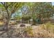 Landscaped backyard featuring a brick fire pit, greenery, and a swing for Gathering gatherings and outdoor enjoyment at 209 S Hydrangea Ave, Polk City, FL 33868