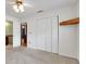 A bright bedroom with closet, wood accent, and neutral carpet, offering versatility and comfort at 209 S Hydrangea Ave, Polk City, FL 33868