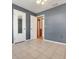 An empty bedroom with tile floors, gray walls, and multiple doors, offering versatility and style at 209 S Hydrangea Ave, Polk City, FL 33868