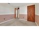 A carpeted bedroom with wood details, featuring a unique door and warm accents for a cozy feel at 209 S Hydrangea Ave, Polk City, FL 33868