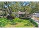 Beautiful home with lush, green lawn and mature trees, creating a peaceful and inviting ambiance at 209 S Hydrangea Ave, Polk City, FL 33868
