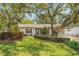 Charming home with a well-manicured lawn, mature trees, and manicured shrubbery enhancing its curb appeal at 209 S Hydrangea Ave, Polk City, FL 33868