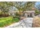 Charming home with well-manicured front lawn, mature trees, and an American flag at 209 S Hydrangea Ave, Polk City, FL 33868