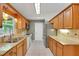 Bright kitchen with wood cabinets, granite countertops, and stainless-steel appliances, offering a functional design at 209 S Hydrangea Ave, Polk City, FL 33868