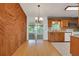 Open kitchen and dining area with wood accents, granite countertops, and sliding door to outdoor space at 209 S Hydrangea Ave, Polk City, FL 33868