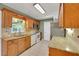Well-lit kitchen with wood cabinets, tile backsplash, granite countertops, and stainless-steel appliances at 209 S Hydrangea Ave, Polk City, FL 33868