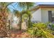 Whimsical iron gate and vine-covered archway amidst a tropical landscape at 209 S Hydrangea Ave, Polk City, FL 33868