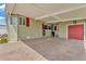 View of carport with painted concrete, red garage door, and space for parking or outdoor activities at 2101 Cypress Cross Dr, Lakeland, FL 33810