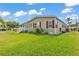 Side view of home featuring green siding, red shutters, lush green lawn, and a cozy screened porch at 2101 Cypress Cross Dr, Lakeland, FL 33810