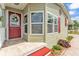 Close-up of the home's front entrance with a red door, wreath, decorative windows, and tidy landscaping at 2101 Cypress Cross Dr, Lakeland, FL 33810