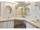 Bright bathroom featuring double sinks, vanities, mirrors, and white cabinets at 211 Sweet Cir, Winter Haven, FL 33884