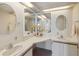 Bright bathroom featuring double sinks, vanities, mirrors, and white cabinets at 211 Sweet Cir, Winter Haven, FL 33884