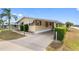 Inviting home with a covered driveway, landscaped lawn, and awning-covered windows at 211 Sweet Cir, Winter Haven, FL 33884