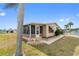 Cozy home with an inviting front porch and well-manicured lawn near palm trees at 211 Sweet Cir, Winter Haven, FL 33884