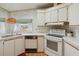 Efficient kitchen with white appliances, cabinets, and natural light from the window at 211 Sweet Cir, Winter Haven, FL 33884