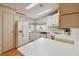 Bright kitchen features white appliances, ample counter space, and laminate wood flooring at 211 Sweet Cir, Winter Haven, FL 33884