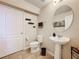 Well-lit half bathroom featuring a pedestal sink, modern fixtures, and a decorative mirror at 2112 Betsy Ross Ln, St Cloud, FL 34769