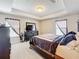 Spacious bedroom with tray ceiling, a neatly made bed, dresser, and soft carpeted floors for comfort at 2112 Betsy Ross Ln, St Cloud, FL 34769