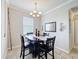 A dining room displays a dark wood table and chairs, neutral walls, and a modern chandelier, creating an inviting ambiance at 2112 Betsy Ross Ln, St Cloud, FL 34769