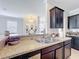 Kitchen bar featuring stainless steel sink, dark cabinets, and granite countertops at 2112 Betsy Ross Ln, St Cloud, FL 34769