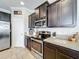 Kitchen featuring stainless steel appliances, dark cabinets, granite countertops, and tiled floors at 2112 Betsy Ross Ln, St Cloud, FL 34769