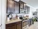Kitchen featuring stainless steel appliances, dark cabinets, granite countertops, and tiled floors at 2112 Betsy Ross Ln, St Cloud, FL 34769