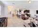Bright living room featuring tile floors, a leather recliner, and an open floor plan that connects to the kitchen at 2112 Betsy Ross Ln, St Cloud, FL 34769