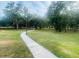 Community walking path through scenic green spaces with mature shade trees at 2112 Betsy Ross Ln, St Cloud, FL 34769