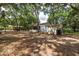 Idyllic backyard featuring mature trees, white outbuildings, and ample space at 2115 W Pipkin Rd, Lakeland, FL 33811