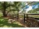 Spacious fenced backyard with mature trees and woodpile at 2115 W Pipkin Rd, Lakeland, FL 33811