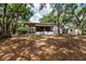 Backyard view showcasing a covered area, storage shed, and natural shade at 2115 W Pipkin Rd, Lakeland, FL 33811