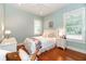 Bright bedroom with hardwood floors features a full bed with floral bedding, and two windows at 2115 W Pipkin Rd, Lakeland, FL 33811