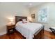 Bedroom with a window, hardwood floors, a queen bed with a white comforter and dark wood furniture at 2115 W Pipkin Rd, Lakeland, FL 33811