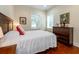 Cozy bedroom features a dark wood dresser and a bed with a white comforter and decorative pillows at 2115 W Pipkin Rd, Lakeland, FL 33811