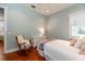 Light blue bedroom has a twin bed with floral pillows, hardwood floors, and a rocking chair at 2115 W Pipkin Rd, Lakeland, FL 33811