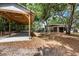 View of a detached carport with a concrete pad and a glimpse of the well-maintained grounds at 2115 W Pipkin Rd, Lakeland, FL 33811