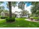Beautifully landscaped home exterior featuring a covered patio and charming outdoor seating at 2115 W Pipkin Rd, Lakeland, FL 33811