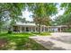 Charming single-story home with a metal roof, wraparound porch, and brick driveway at 2115 W Pipkin Rd, Lakeland, FL 33811