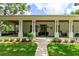 Inviting front porch with decorative columns, a swing, and manicured landscaping at 2115 W Pipkin Rd, Lakeland, FL 33811