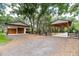 Detached garage with two garage doors, next to a carport and fenced yard at 2115 W Pipkin Rd, Lakeland, FL 33811