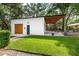 Exterior shot of garage and yard showing grassy lawn and modern wood accented architecture at 2115 W Pipkin Rd, Lakeland, FL 33811