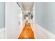 Bright hallway features a sliding closet door, hardwood flooring, and traditional wainscoting at 2115 W Pipkin Rd, Lakeland, FL 33811
