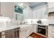 Bright kitchen featuring a farmhouse sink, stainless steel appliances, white cabinets, and subway tile backsplash at 2115 W Pipkin Rd, Lakeland, FL 33811